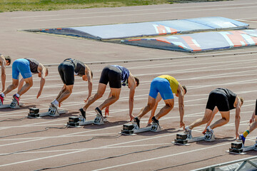 group runners athletes in starting blocks at athletics competition