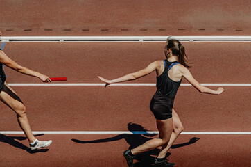 Fototapeta na wymiar relay race female athletes runners track and field athletics competition