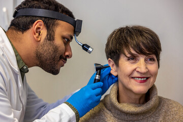 ENT doctor examinine patients ear with endoscope
