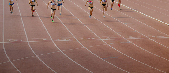group female athletes run finish line at stadium