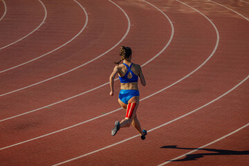 female athlete running track with kinesio tape on her leg
