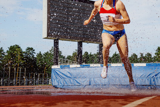 female athlete running steeplechase in athletics competition