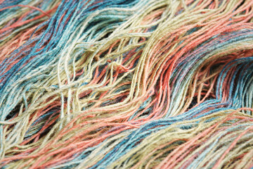 Threads from natural organic sheep wool. Unwound skein of multicolor rainbow knitting yarn.