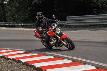 Rider  in black helmet on red classic vintage motorcycle in mountains