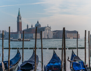 Gondolas docked by the lagoon in Venice, Italy and Saint Giorgio Maggiore in the background
