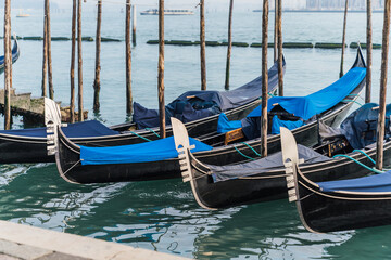 Fototapeta na wymiar Gondolas docked by the lagoon in Venice, Italy