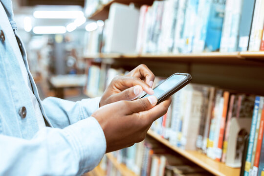 Education, hands or black man with phone in library for research, advertising or blog content. Search, social media or university student on smartphone for learning, scholarship study or reading news