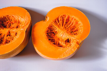 Close up view against a white background of a pumpkin cut in half