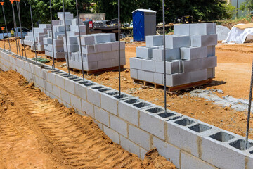 On construction site cement blocks that are ready be used to build wall of house are stacked up