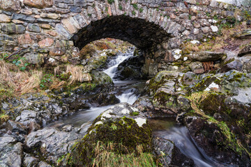 Ashness Bridge in the Lake District with waterfall and long exposure to produce motion in the water