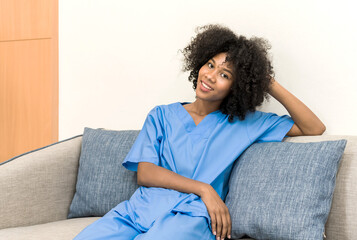 Young African American nurse in uniform sitting and relax on sofa, black female doctor sit on...