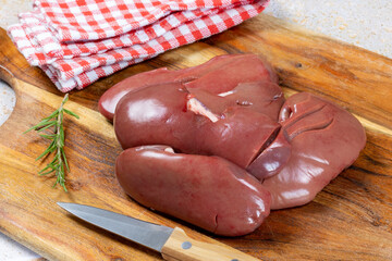 rognons de porc crus isolés sur une planche à découper