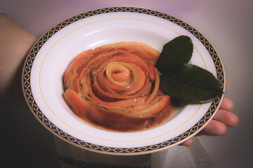 Close up view on a white background of cooked cut peppers in a plate