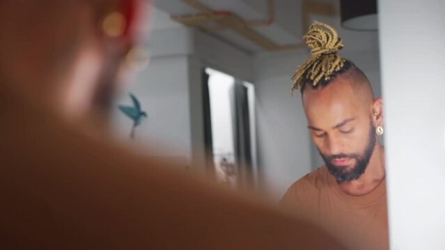 Handsome homosexual man who applies powder to his face. LGBT community with freedom for homosexuals. Black male gay transgender model. The rights of sexual minorities. Gender Diversity Concept