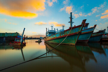 Fototapeta na wymiar Fishing boats and evening sky,Picture of a fishing boat facing a high oil crisis at sunrise, Thailand