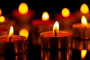 candle,Burning candles on a dark memorial day surface,Candle,
Tea Light,Black Background,Beauty,Black Color,Bright,Brightly Lit,