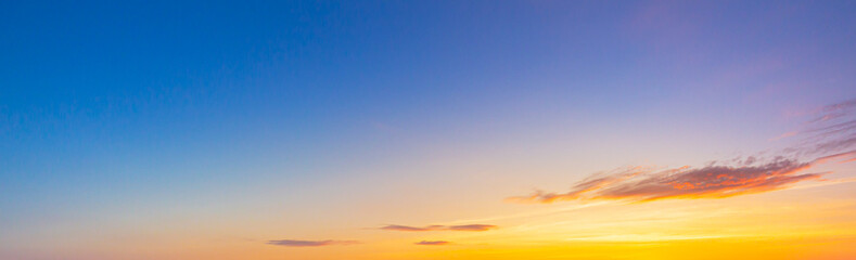Obraz premium orange sky and clouds background,Real majestic sunrise sunset sky background with gentle colorful clouds without birds.Panorama, large