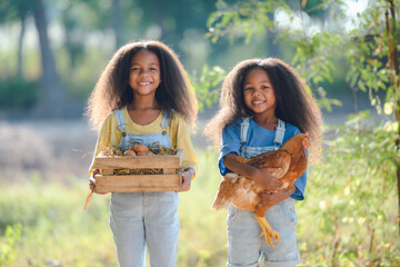 black girl children two people standing side by side Children holding eggs and holding chickens...