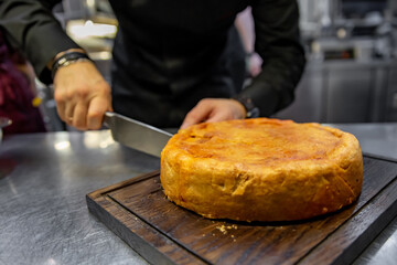 chef hand cut meat pie on restaurant kitchen