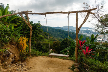 Wooden swing on the mountain overlooking the city