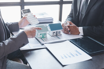 Business property,real estate and investment concepts. Real estate agent present terms of the home purchase agreement to customer,investor discussing real estate investment