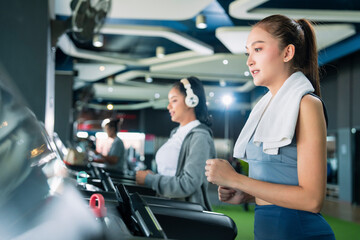 asian adult female sport woman jogger running on treadmill athletic working out active healthy lifestyle with cheerful freshness sweaty cardio exercise at fitness gym sport club morning wellness day