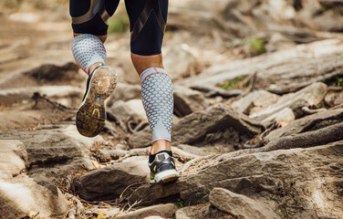 legs male runner in compression socks run over rocks