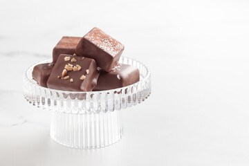 Chocolate bonbons with praline on white marble background