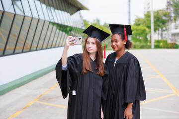 student wearing gown and making photo by smartphone  graduating. Happy graduate success and celebration. Congratulation