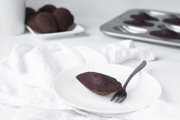 Chocolate madeleines on a ceramic plate, plain chocolate madeleine cake or cookies