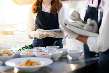 take note on book. Cooking class. culinary classroom. group of happy young woman multi-ethnic students are focusing on cooking lessons in a cooking school.