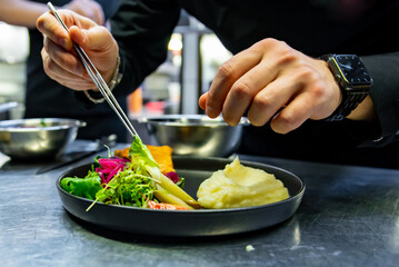 chef hand preparing Meat Pie with mashed potato and salad on restaurant kitchen
