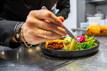 chef hand preparing Meat Pie with mashed potato and salad on restaurant kitchen