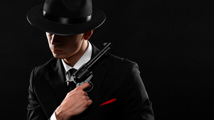 Stylish portrait of gangster from 1940s with a gun.
