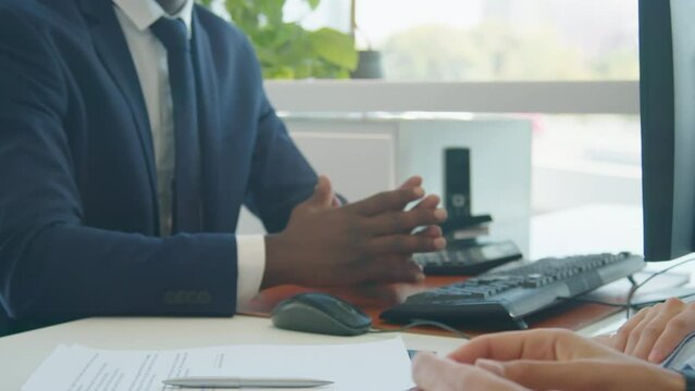 Medium section shot of unrecognizable man sitting at desk with his wife in front of salesperson successfully buying new car