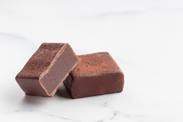 Chocolate bonbons with praline on white marble background