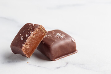 Chocolate bonbons with praline on white marble background