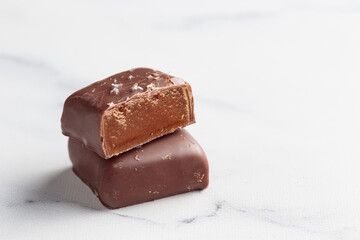 Chocolate bonbons with praline on white marble background