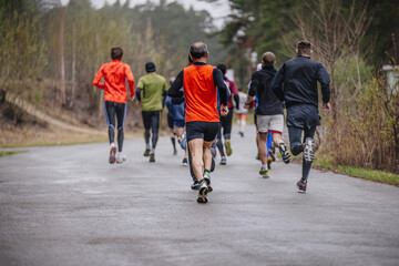 Fototapeta premium group runners run race in rainy weather