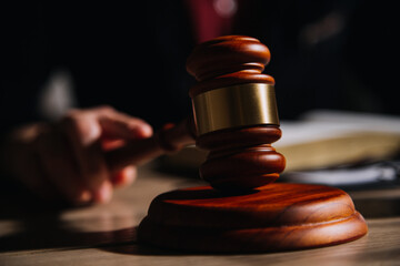 Justice and law concept.Male judge in a courtroom with the gavel, working with, computer and...