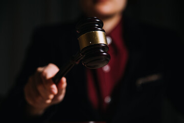 Justice and law concept.Male judge in a courtroom with the gavel, working with, computer and...