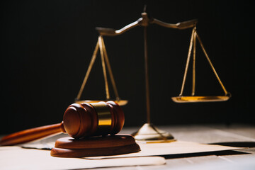 Justice and law concept.Male judge in a courtroom with the gavel, working with, computer and docking keyboard, eyeglasses, on table in morning light