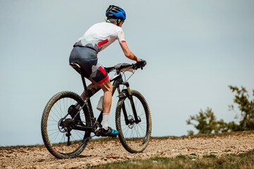 Fototapeta na wymiar male athlete on mountainbike riding gravel trail