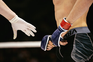 referee and mma fighter in ring after fight