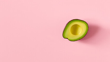 Avocado fruit. On a pink background. Sliced avocado. Avocado pulp.