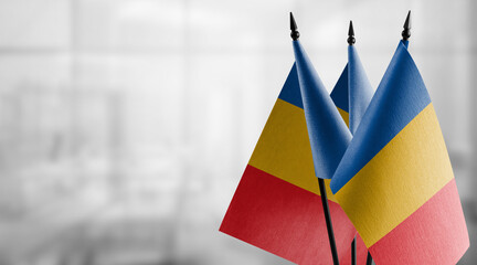 Small flags of the Chad on an abstract blurry background