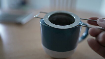 Preparing tea with infuser mug close up. hot morning breakfast beverage