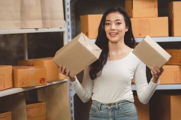 woman entrepreneur's hand holding package of parcel box, Preparing pack delivery packet product for selling online of home shipping service, Startup with small business marketing concept