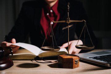 Justice and law concept.Male judge in a courtroom with the gavel, working with, computer and docking keyboard, eyeglasses, on table in morning light