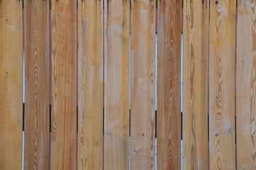 Background or texture of a light brown wooden wall. Natural wooden background of vertical planks.